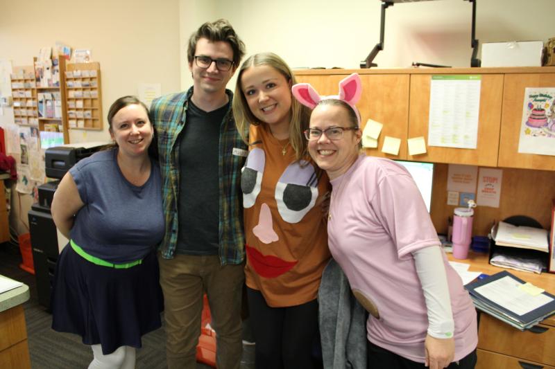 Four people posing in toy story costumes